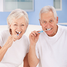 Photo of older couple brushing teeth